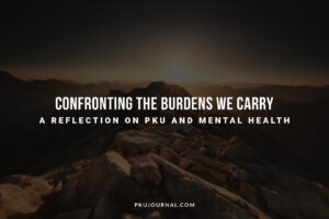 Silhouetted mountain ridge at sunrise with the text "Confronting the Burdens We Carry: A Reflection on PKU and Mental Health" overlaid in white, with the PKUJournal.com wordmark beneath.
